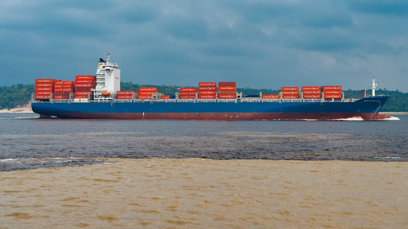 Containership sailing along the meeting of waters (Solimoes and Negro rivers) in the Amazon